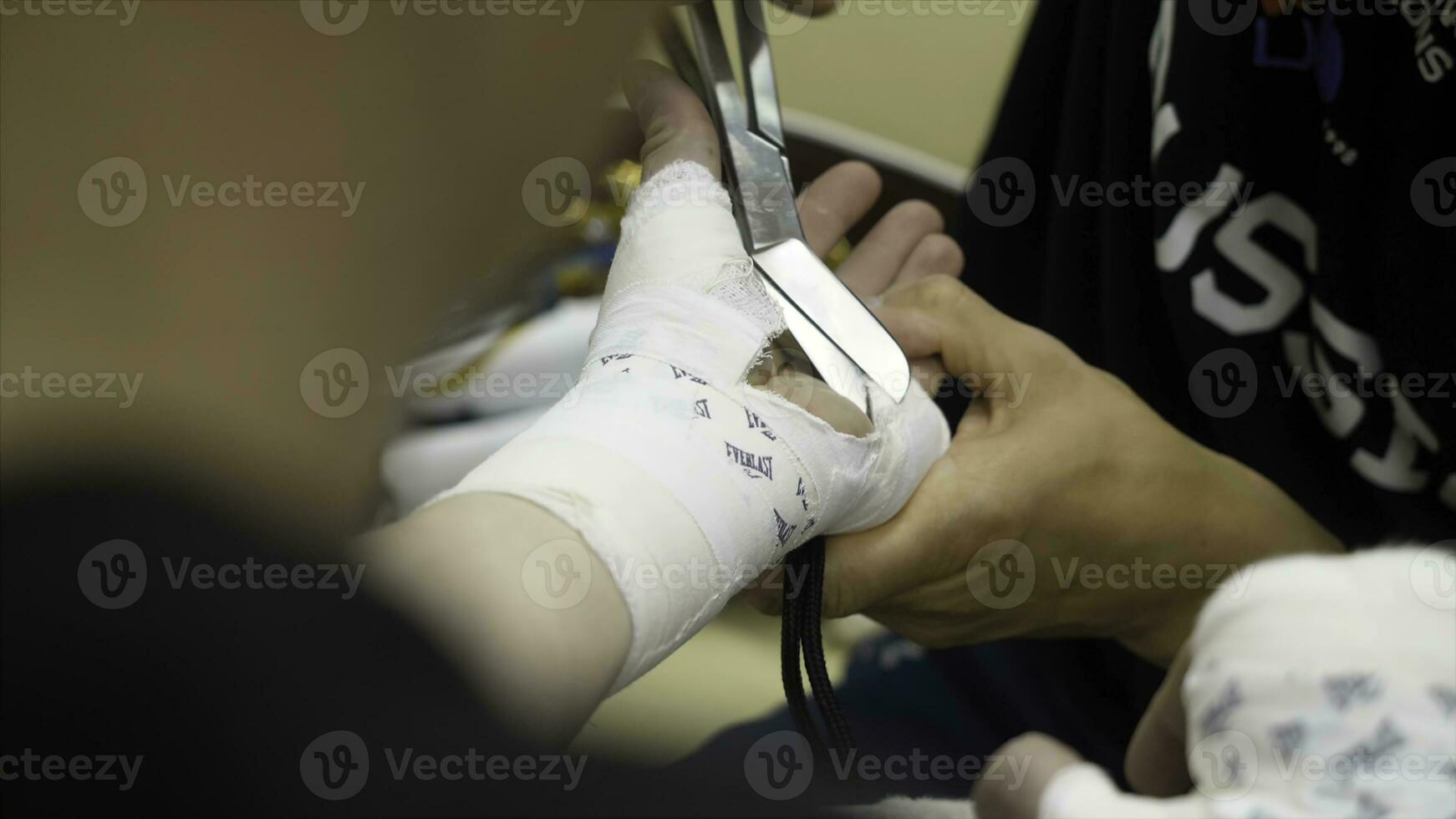 Boxing Trainer or Manager Wrapping Hands of a Boxer Close Up Shallow Depth of Field - Preparing For Boxing Match - Doctor Wrapping Possible Fractured or Broken Hand of Injured Person photo