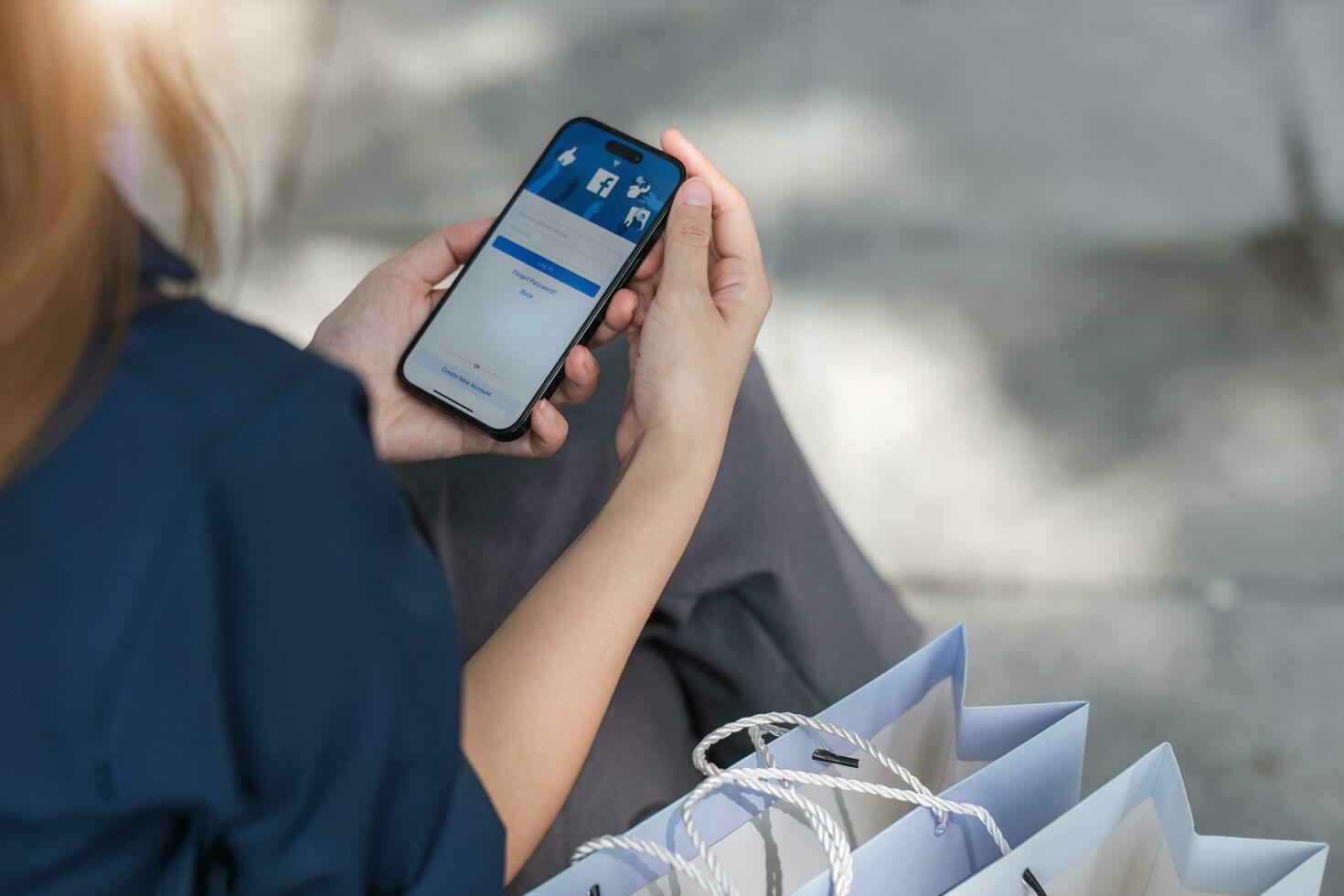 Facebook social media app logo on log-in, sign-up registration page on mobile app screen on iPhone 14 in person's hand working on e-commerce shopping online photo