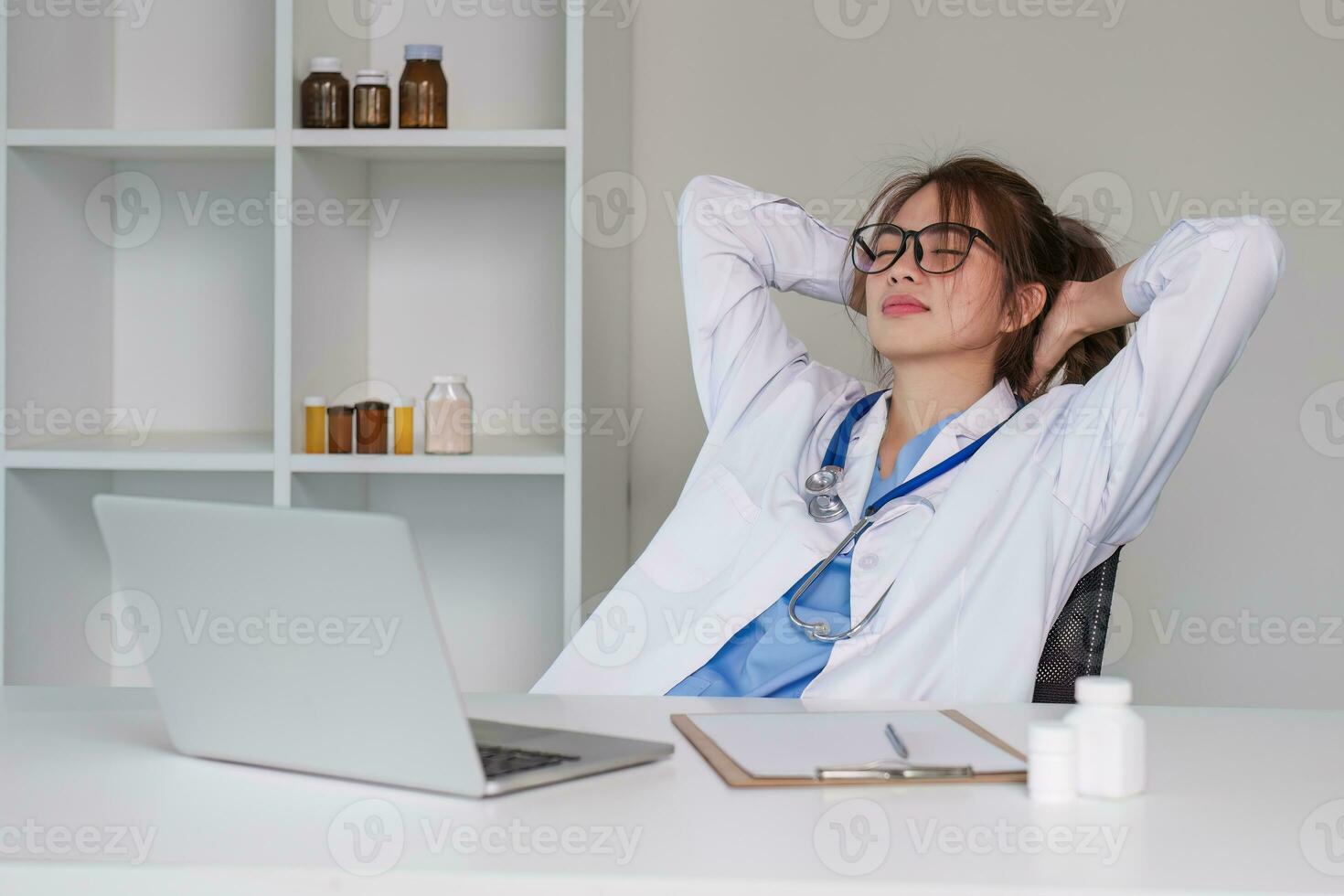 Stressed young female doctor looking at laptop, work related chaos, worried about mistake at work The stressed-out, unhappy medical professional is tired of solving computer problems at work. photo