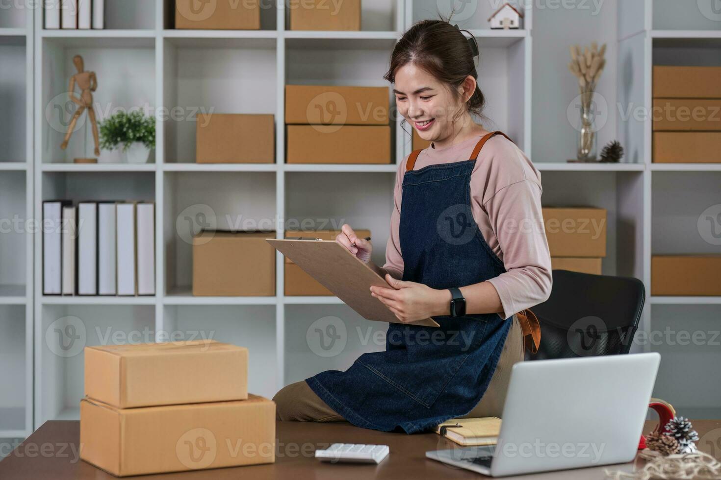 Startup small business entrepreneur SME, asian woman packing cloth in box. Portrait young Asian small business owner home office, online sell marketing delivery, SME e-commerce telemarketing concept photo