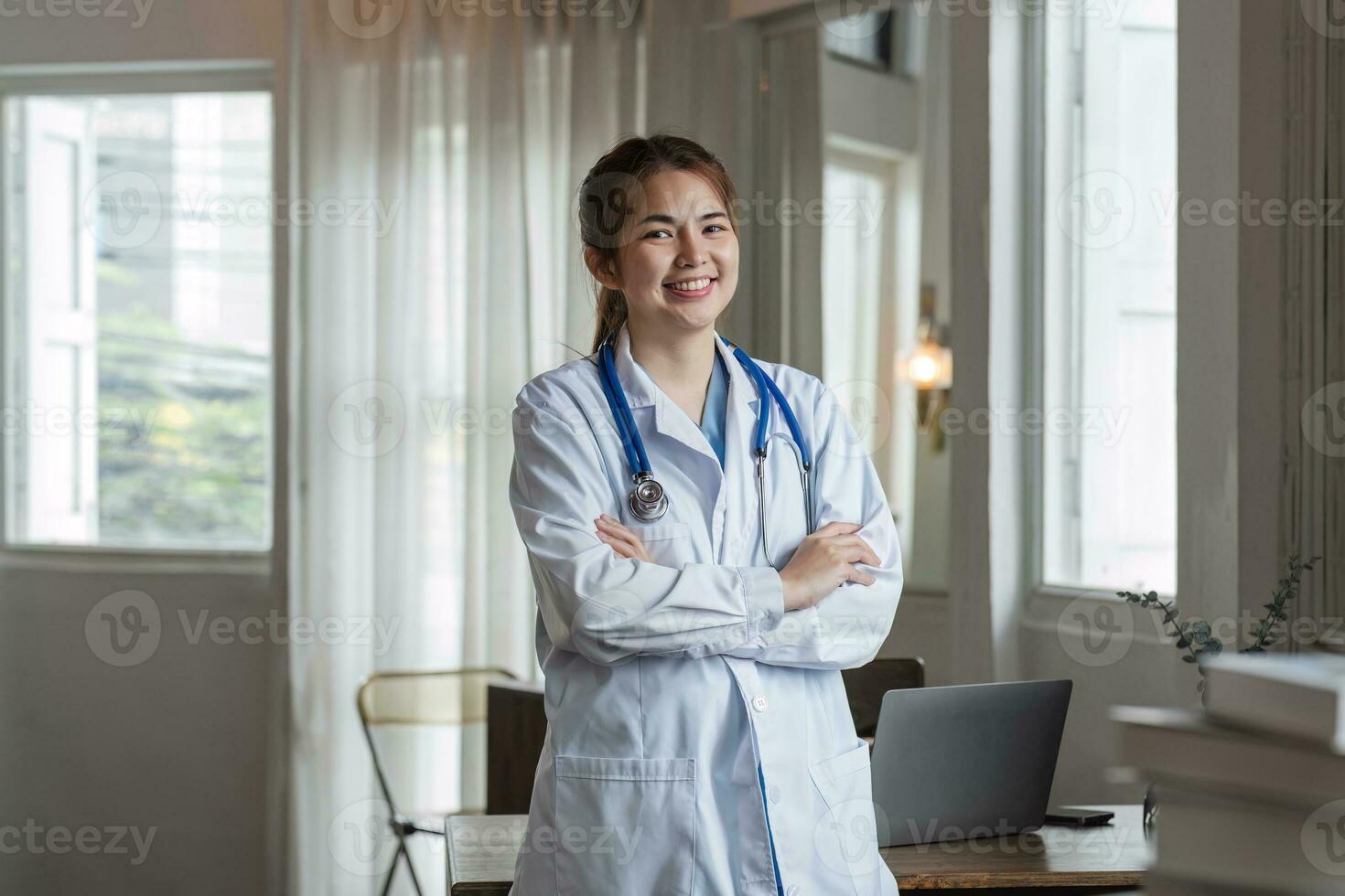 sonriente hembra médico vistiendo un estetoscopio en el del doctor oficina en el hospital foto