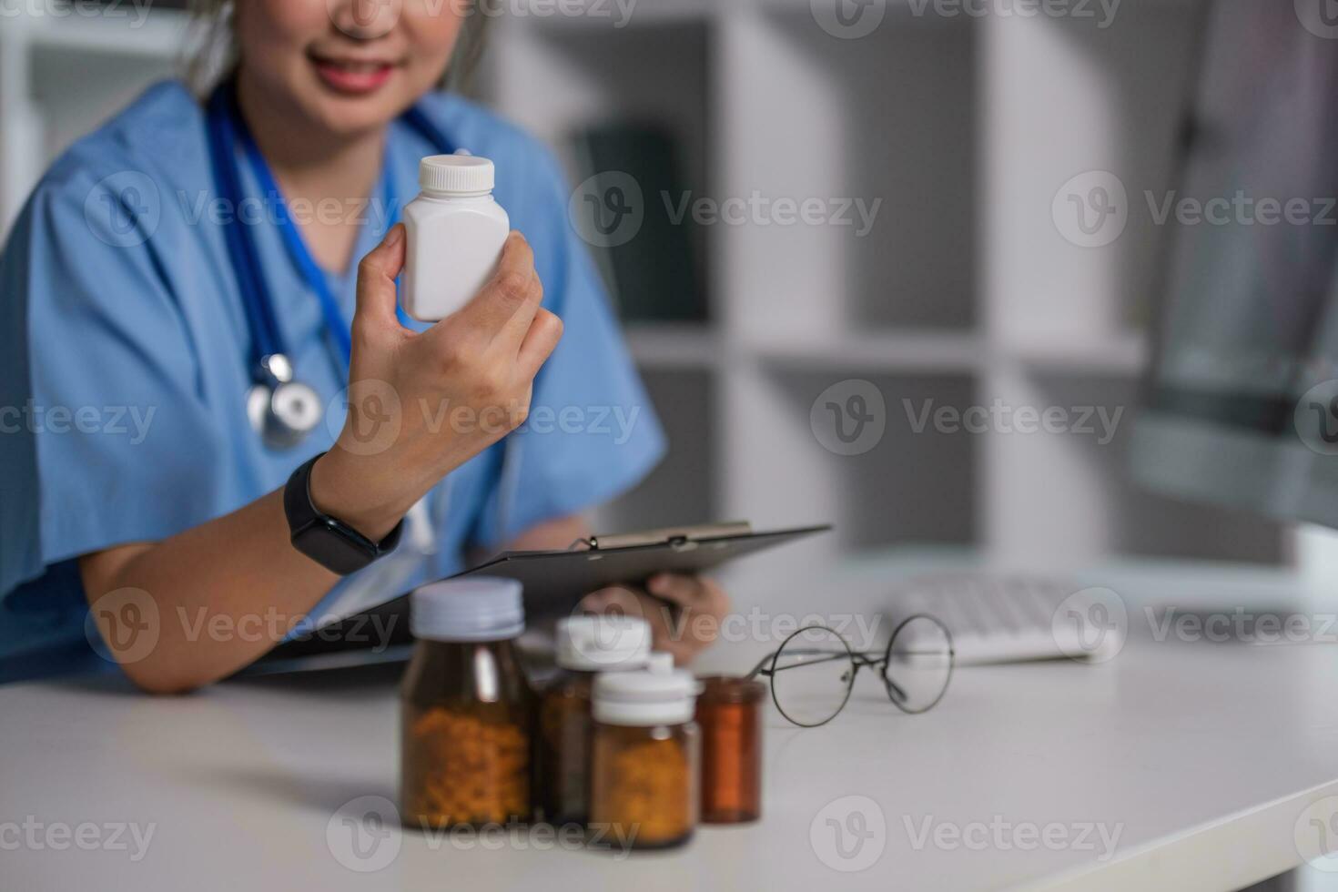 Hand of pharmacist holding plastic pill-bottle while showing it to one of patients during online consultation photo