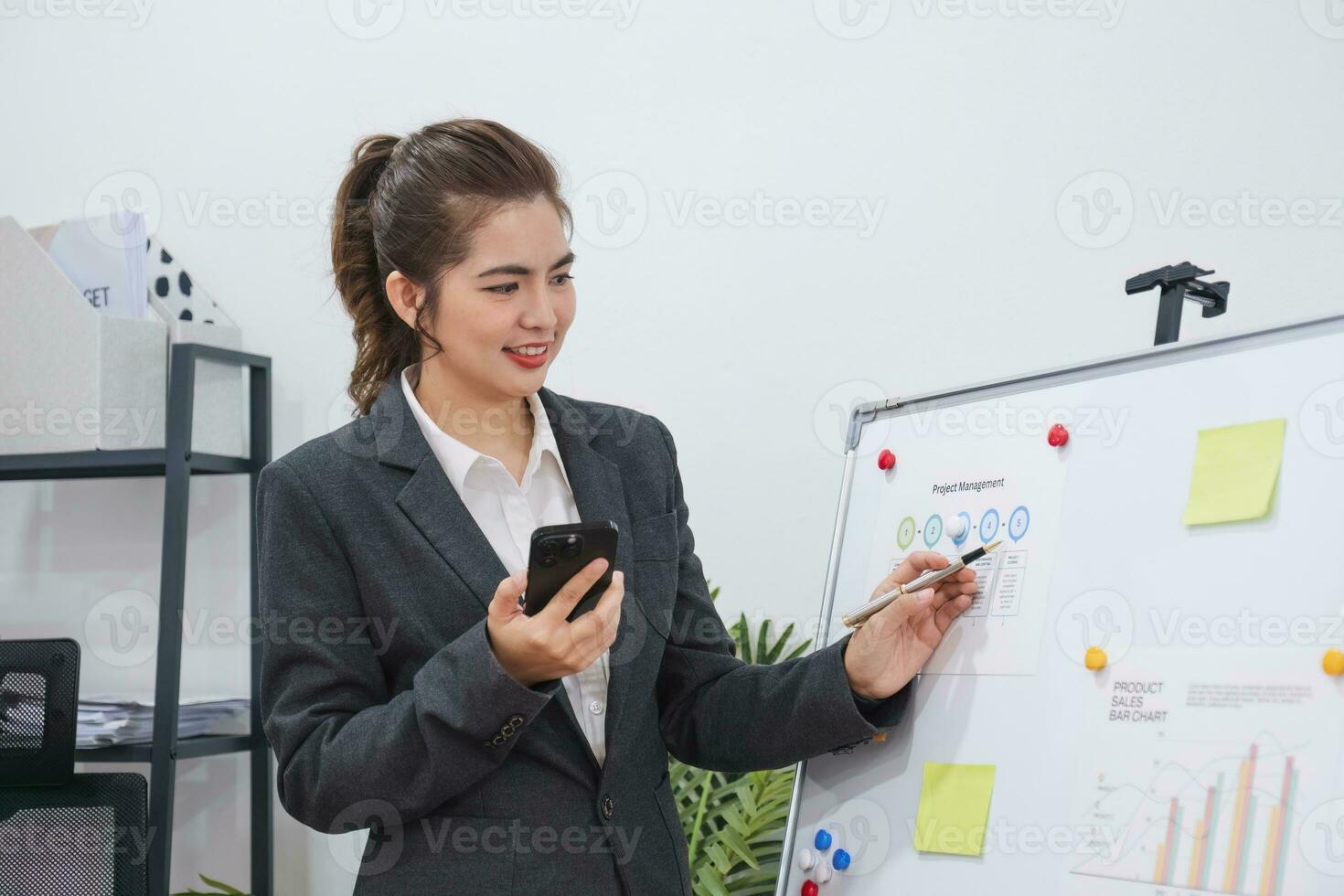 Young businesswoman presenting at a conference using stock market graph paper for analysis Quality improvement plan for next month symposium Organizational concept.. photo