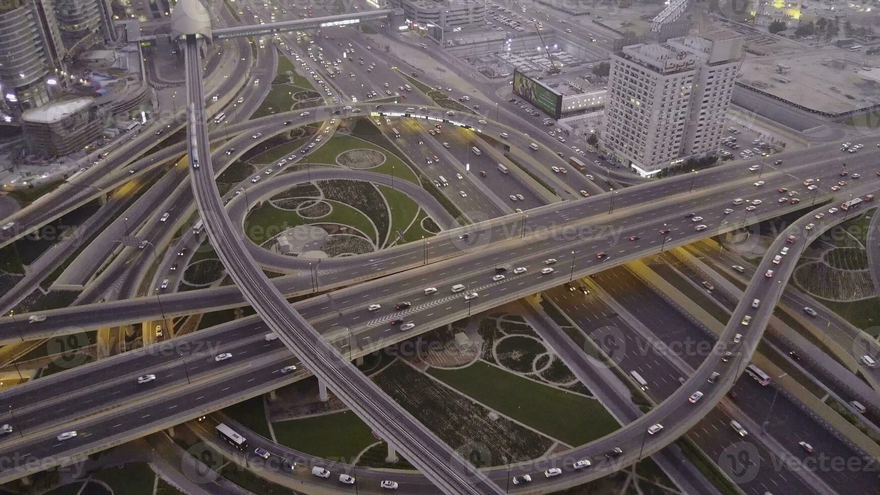 Aerial top view of highway junction with traffic in Dubai, UAE, at sunset. Famous Sheikh Zayed road in Dubai downtown. Transportation and driving concept view from rooftop photo