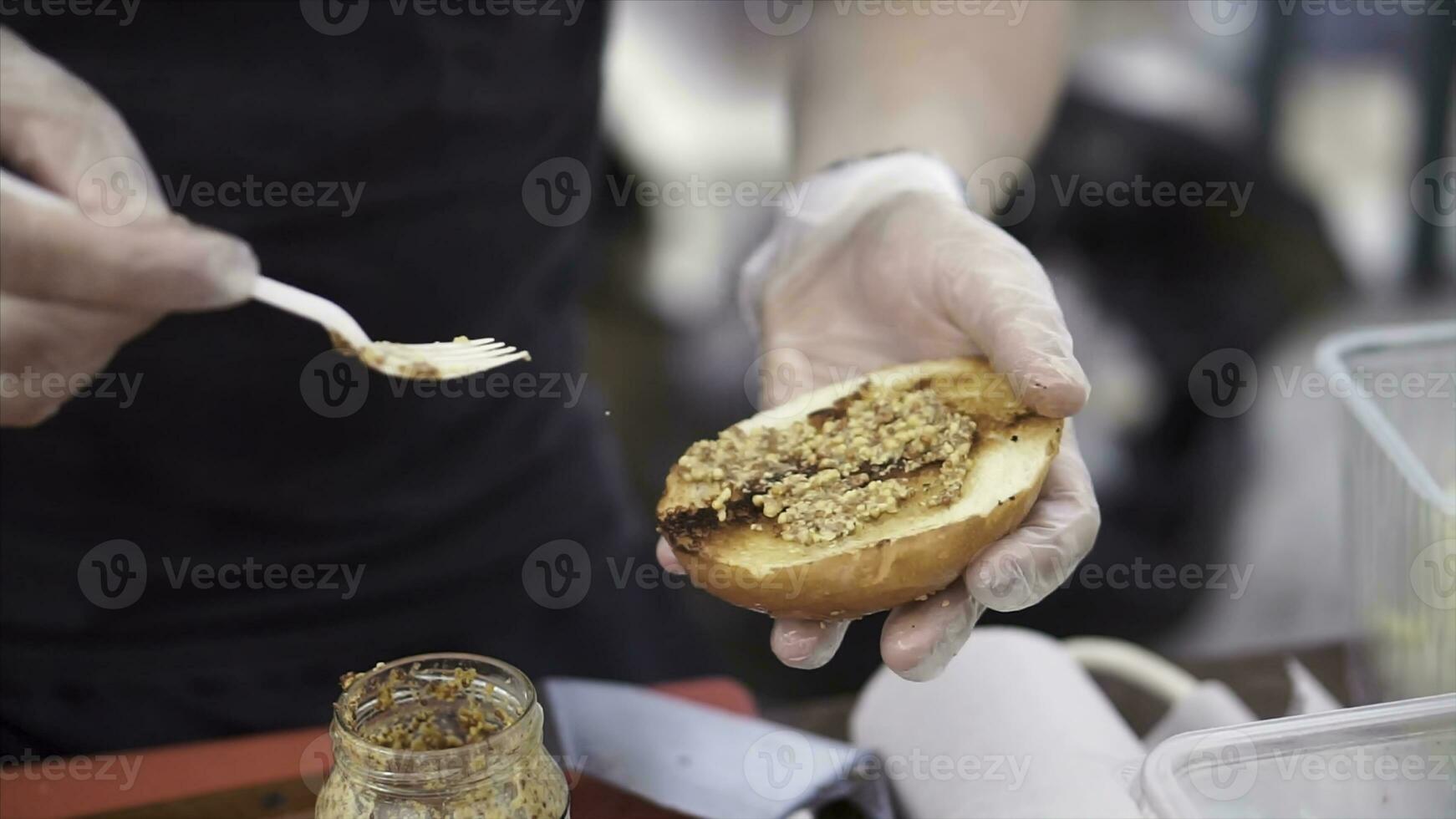 Potatoes prepare on a grill. Clip. Baking potatoes on the grill, the cook lubricates the potatoes with sauce. Hand Using Tongs For Turning potatoes on the Barbecue. photo