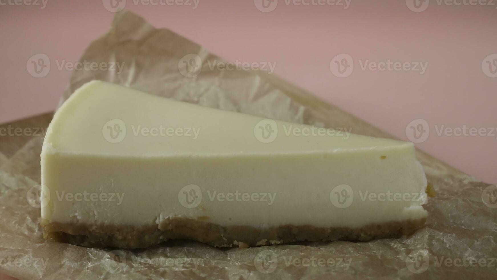 Delicious slice of cheesecake, which is pouring by thin stream of caramel sauce. Frame. Close-up photo
