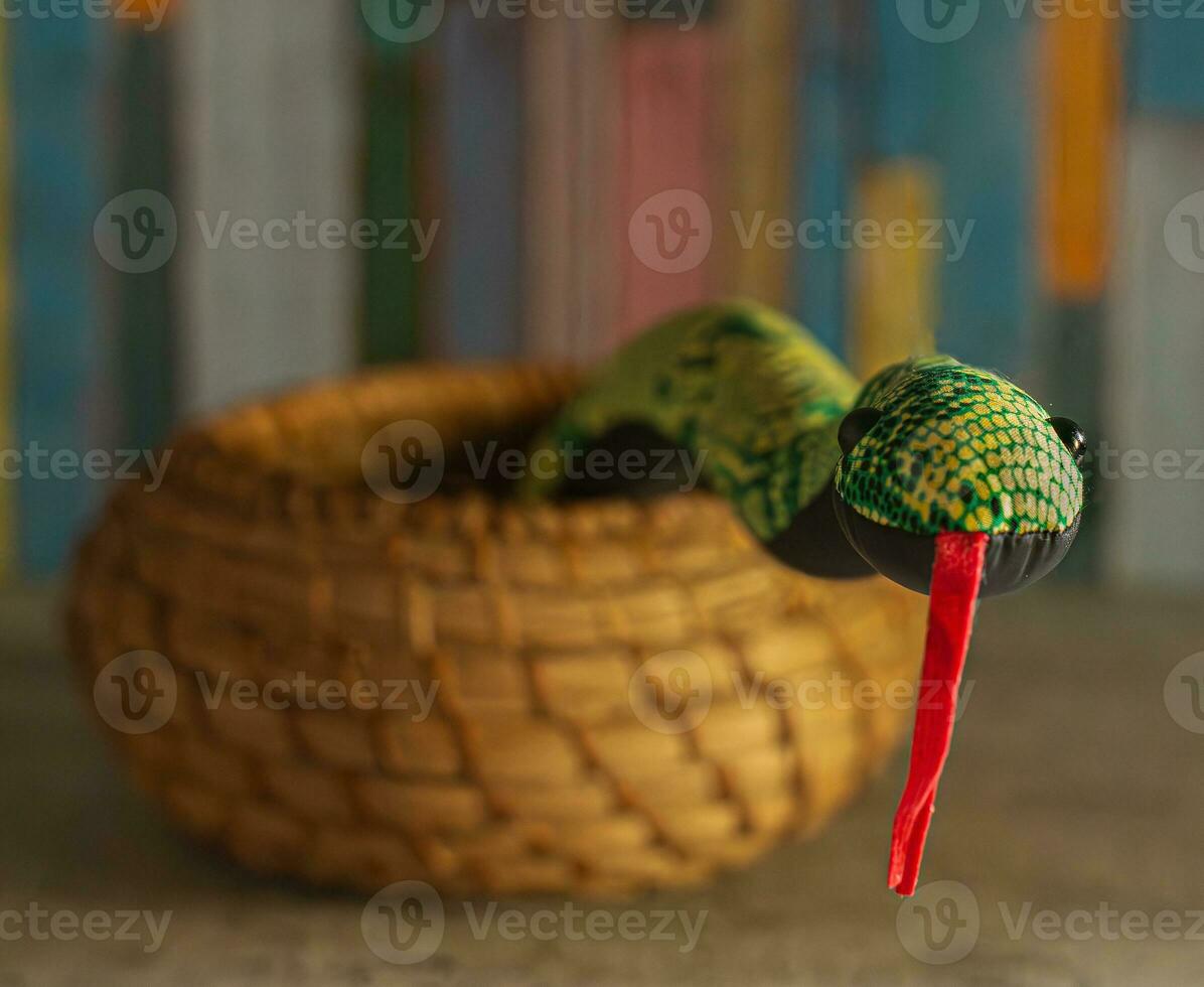 Cute Stuffed Toy Snake Charmer Rising from Basket photo