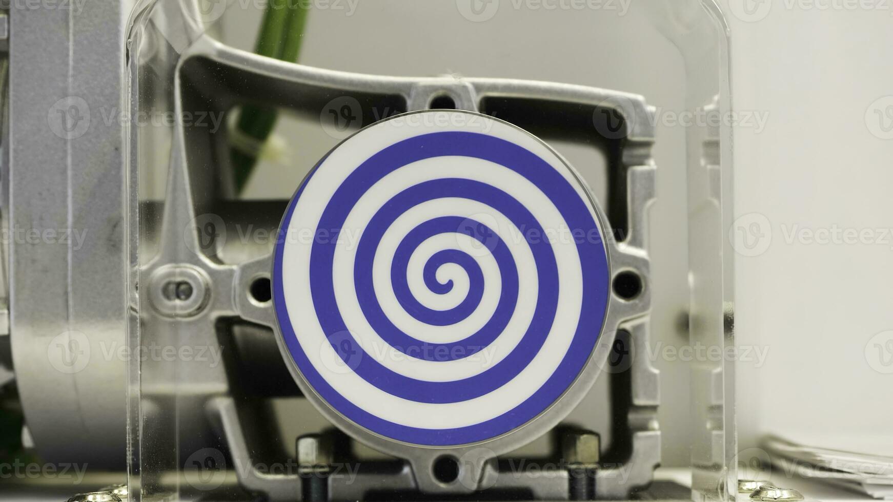 Rotating blue spiral on white background. HDR. Close up of automated mechanism with rotating hypnotic spiral, concept of hypnosis and psychotherapy. photo