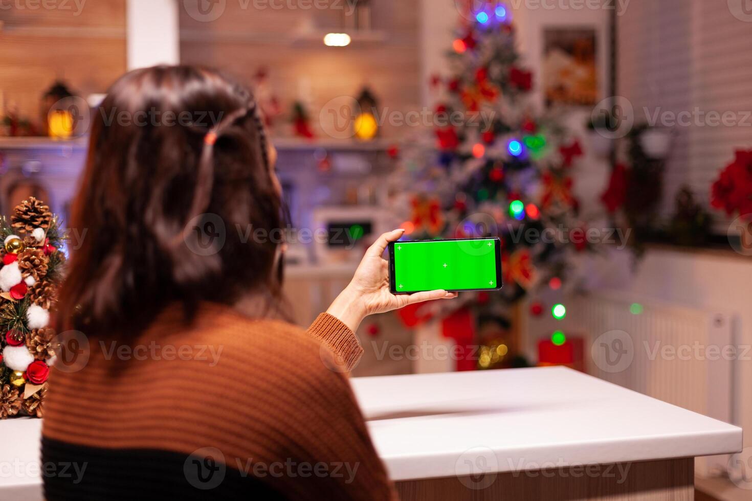 Young woman holding smartphone with green screen for virtual technology on mockup template. Caucasian person analyzing digital device with chroma key to view background design concept photo