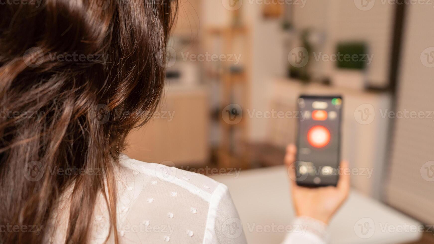 Using smartphone with technology to control home lighting system. Person in apartment holding telephone with touchscreen and app for lights. photo