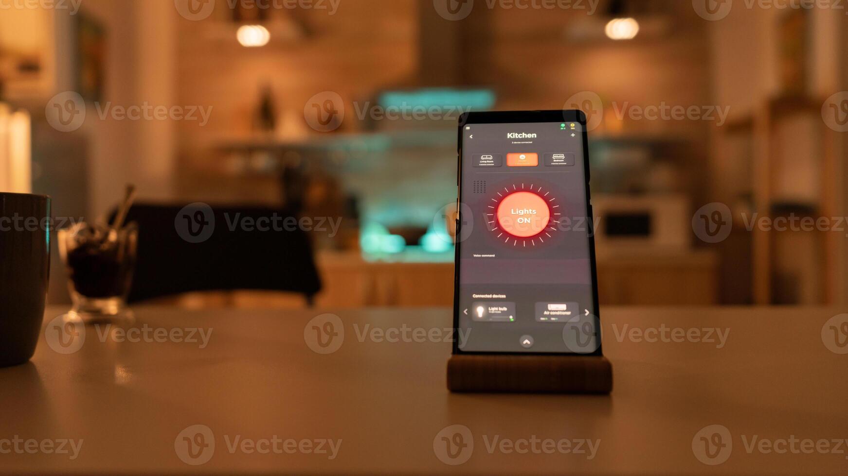 Controlling light bulb temperature and intensity with smartphone application. Phone with touching screen late at night with technology to change lights in home. photo