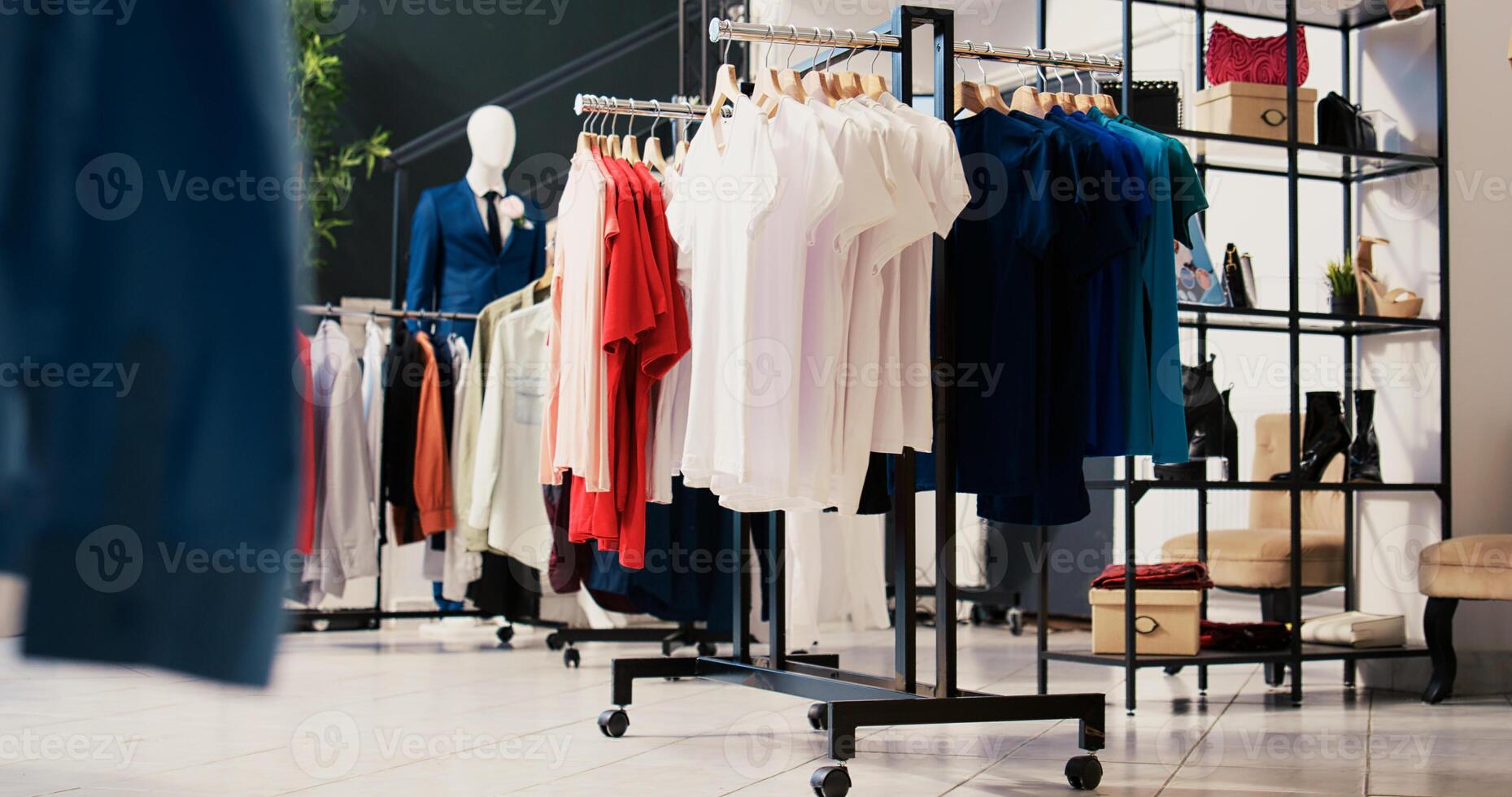 Empty modern boutique in shopping centre, new fashion collection on racks. Fashionable clothes on hangers, clothing store filled with merchandise and accessories at discount for clients photo