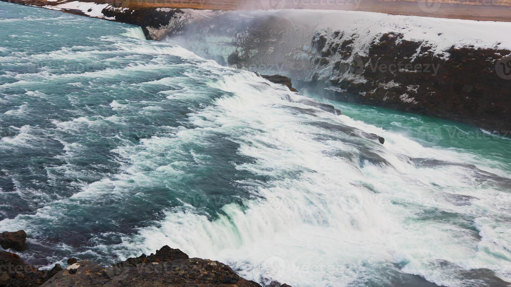 Beautiful water stream iceland nature with snowy fields and mountains, gullfoss waterfall in reykjavik. Majestic river flow in wilderness with scandinavian landscapes and cliffs, spectacular scenery. photo