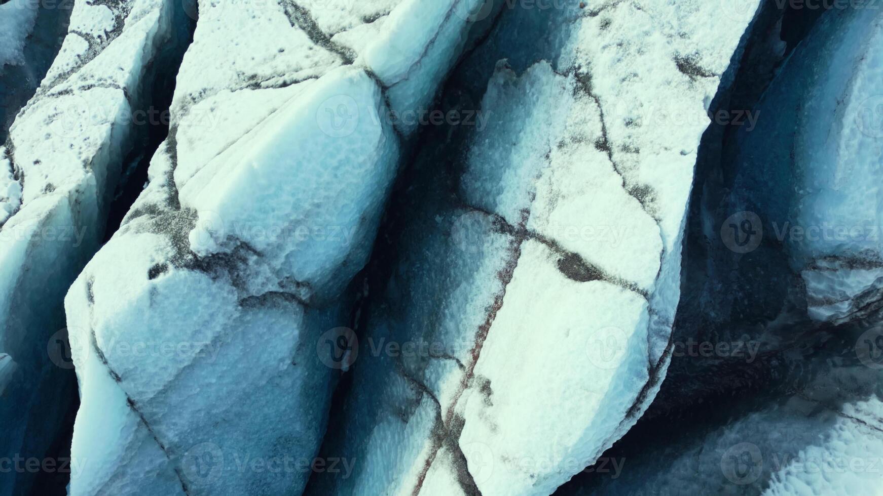 Aerial view of vatnajokull ice mass in iceland, beautiful icelandic glacier with huge crevasses and ice caves. Blue diamond shaped icebergs on nordic scenic landscape. Slow motion. photo