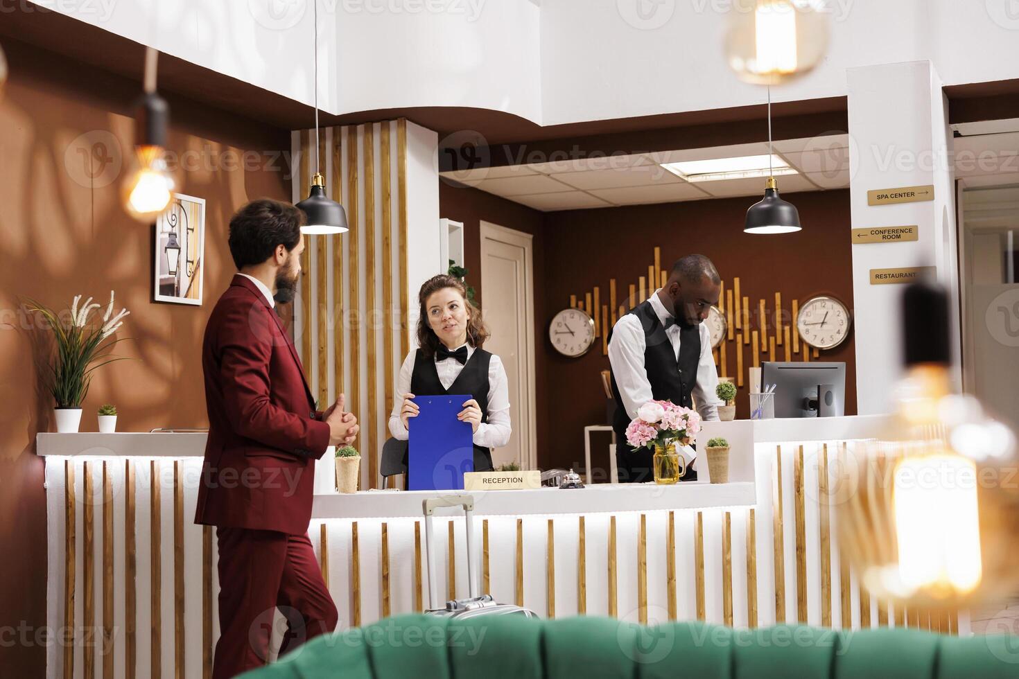 Hotel concierge greet client at reception, providing luxury accommodation services. Businessman finishes check in process, marking the beginning of business trip and preparing for productive stay. photo