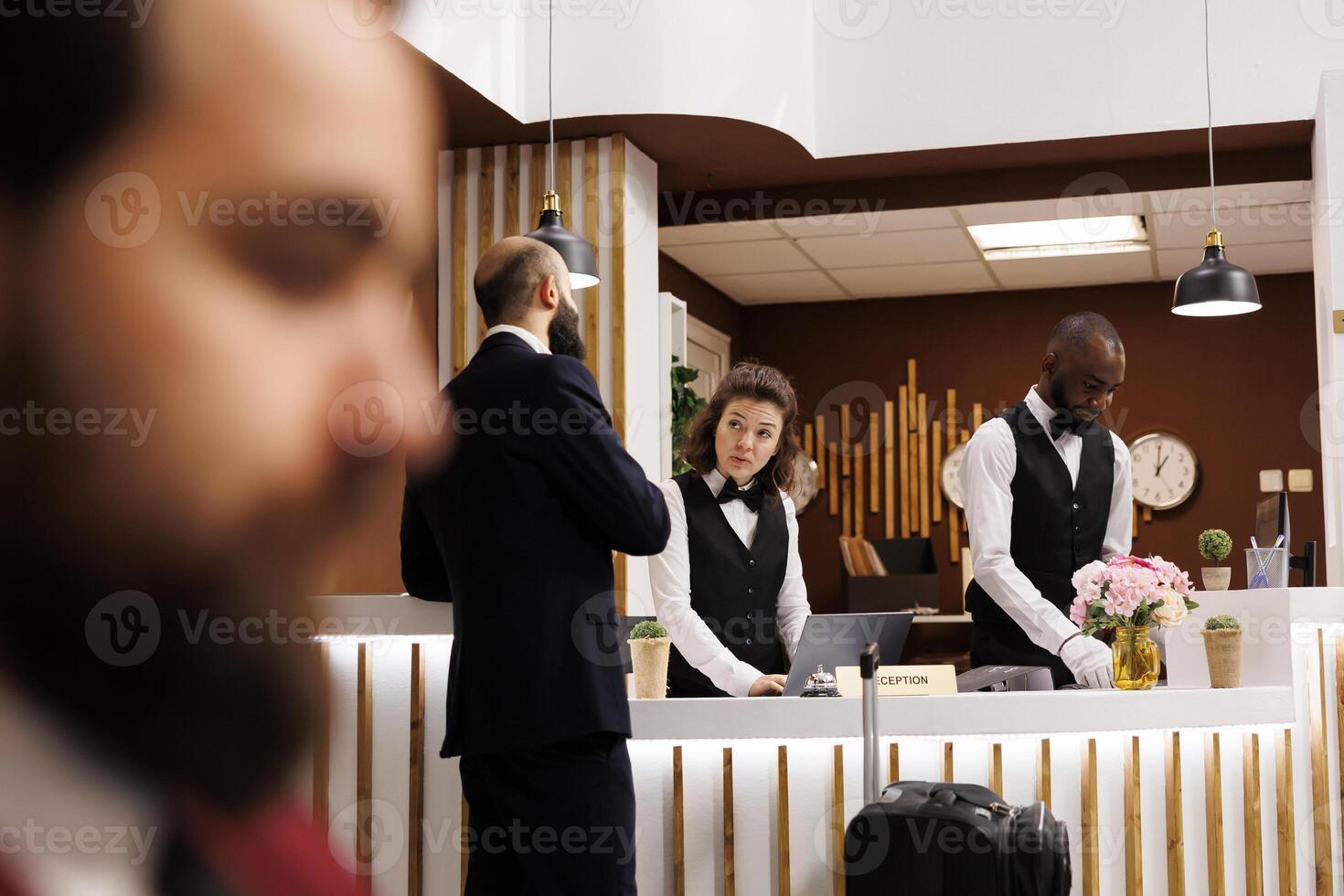 Professional signing registration forms, arriving at hotel with business trip accommodation. Company employee going through check in process before attending conference with executive board. photo