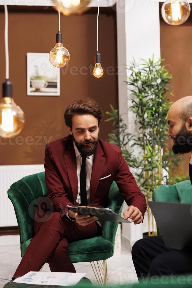 Diverse individuals dressed with suits engage in business related activities, highlighting collaboration and teamwork. Partners discussing freely, exchanging new professional ideas. photo