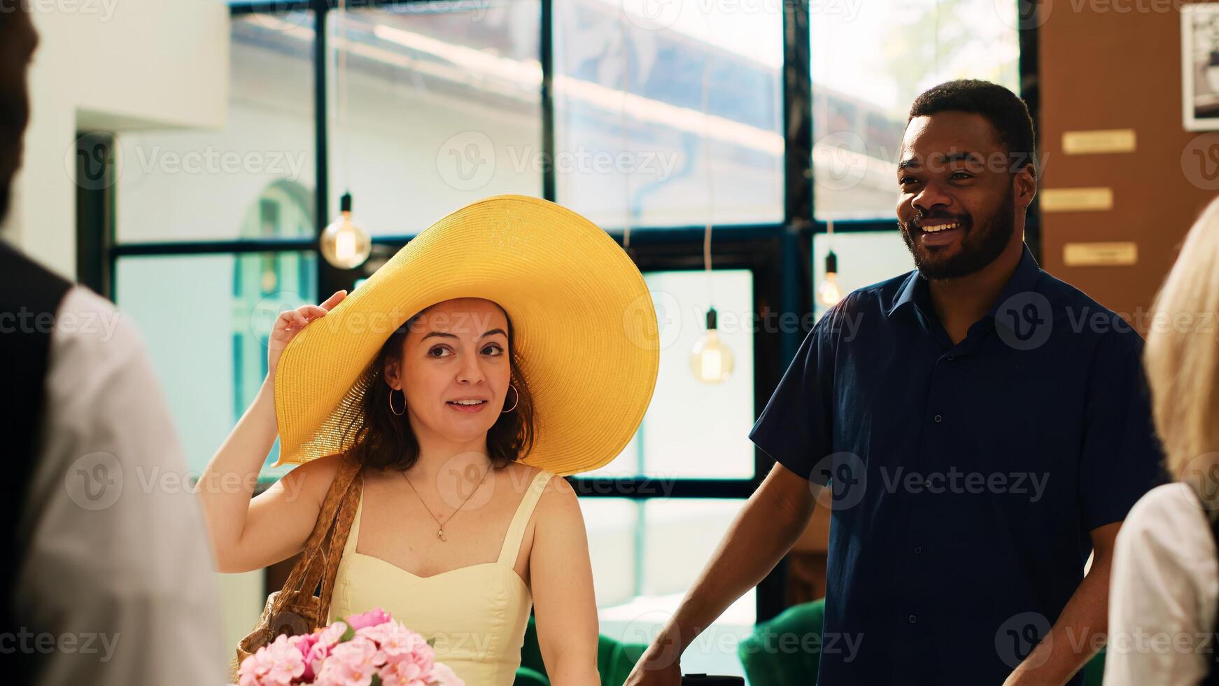 Hotel guests arriving at exotic seaside resort, travelling on honeymoon holiday trip. Diverse couple asking receptionist about check in registration procedure, luxury tropical service. photo