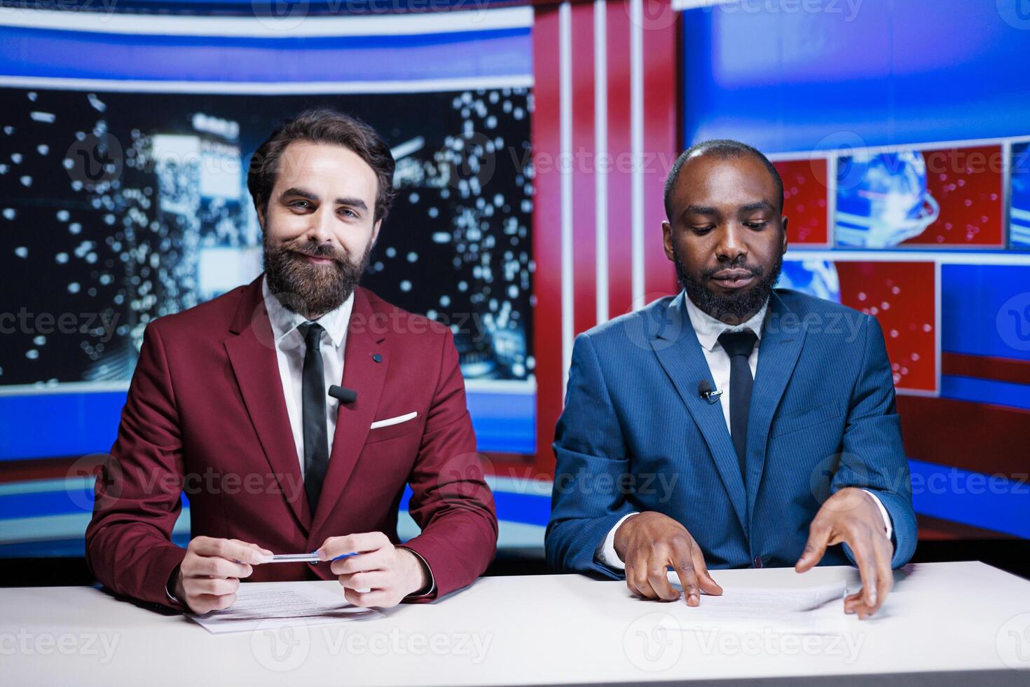 Newscasters team hosting night show in newsroom, debating important events worldwide for television content. Diverse presenters broadcasting live discussion, entertainment segment. photo