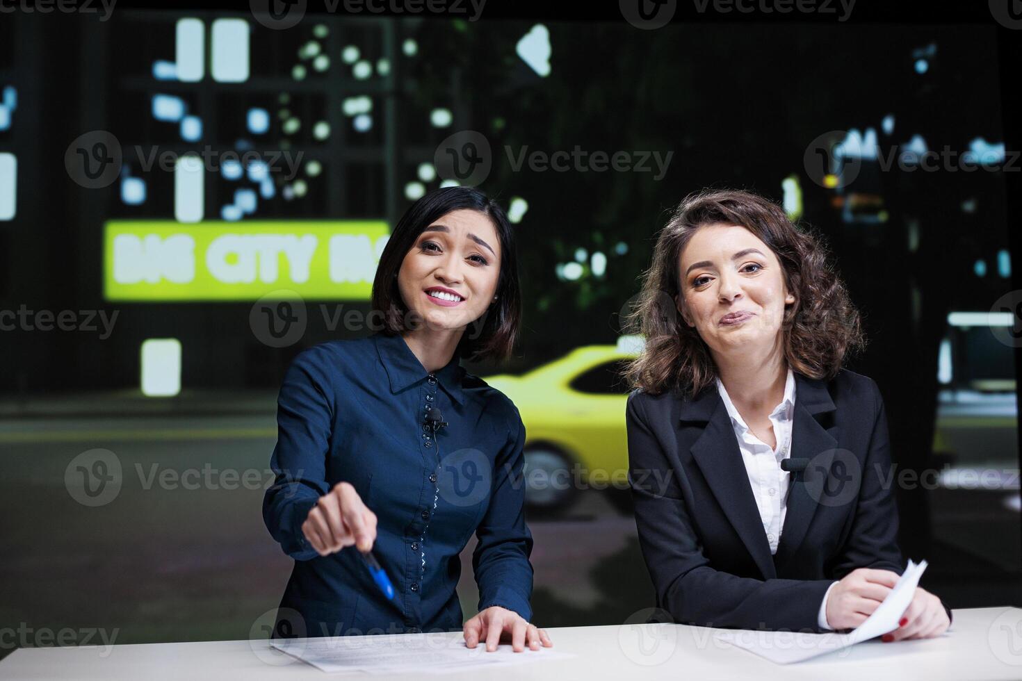 Newscasters team hosting night show in studio, reporting current news topics from media outlets. Diverse presenters women addressing all celebrity scandals and creating tv content. photo