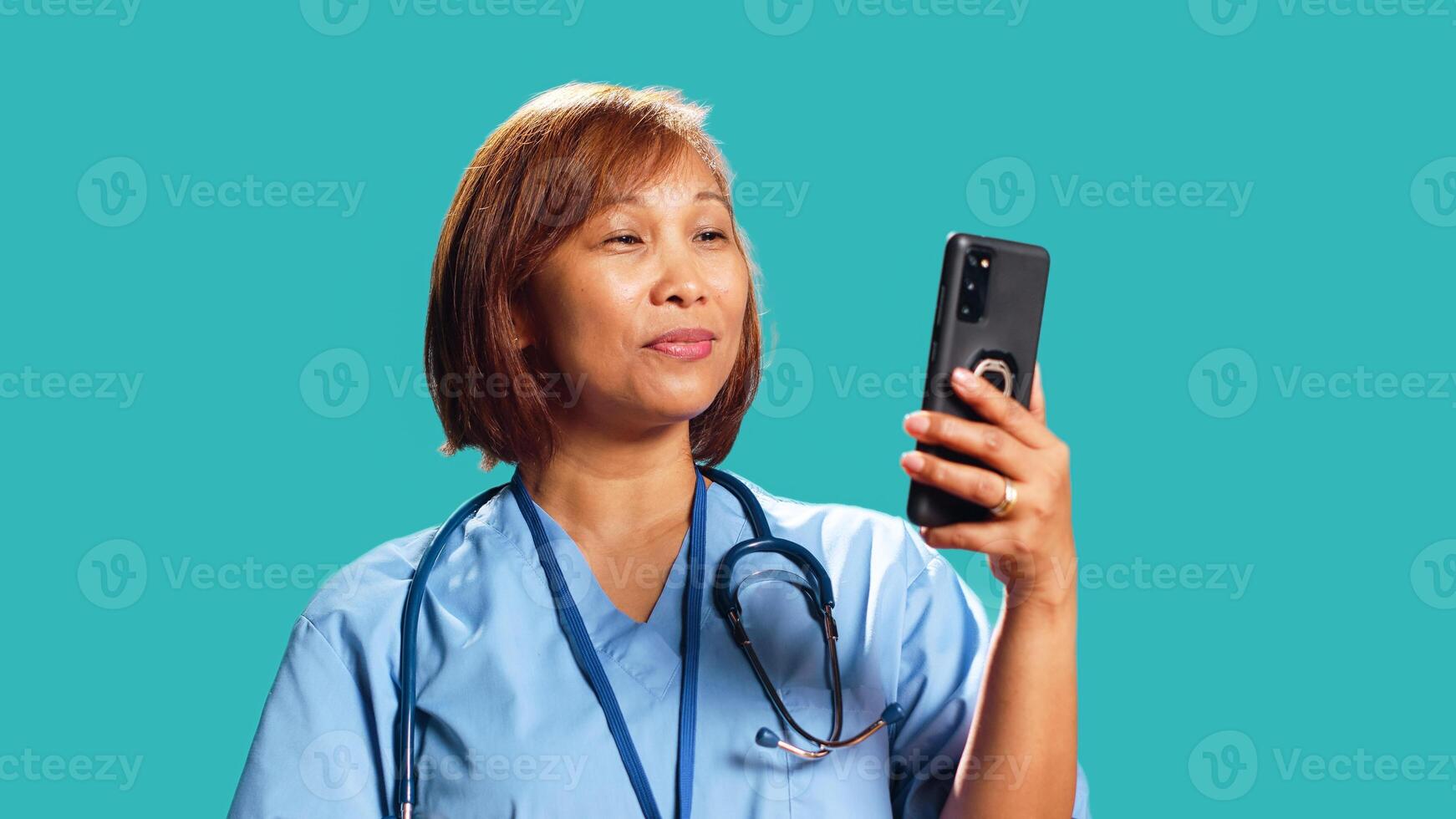 cerca arriba Disparo de contento enfermero en en línea video conferencia reunión terminado el teléfono, saludo gente. alegre hospital empleado en telesalud llamada con pacientes, aislado terminado estudio antecedentes foto