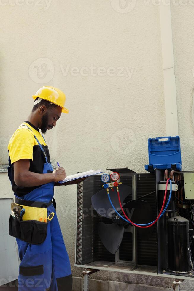 Certified technician doing inspection of freon levels and necessary repairs to prevent major breakdowns. Seasoned mechanic troubleshooting hvac system, writing findings on clipboard photo