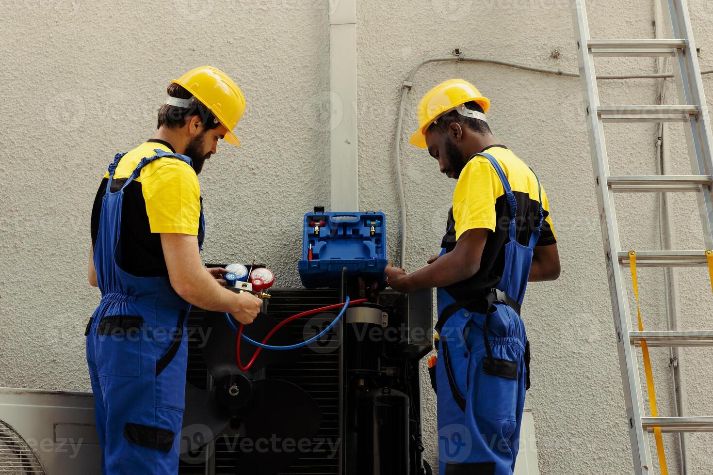Professional workers fixing broken blower fan causing frozen evaporator coil, resulting in reduced cooling performance. Qualified electricians optimizing condenser capacity photo