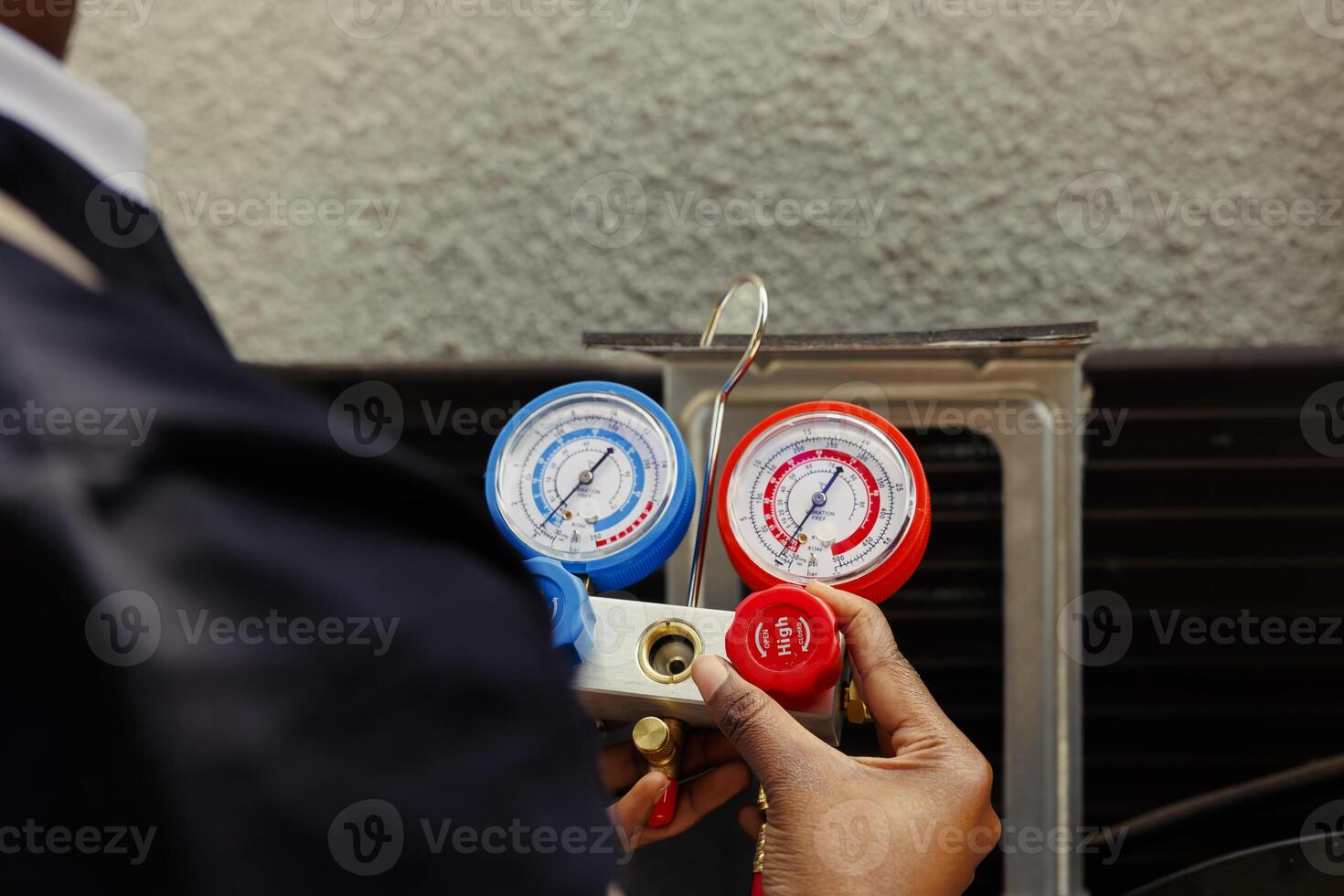 Pressure indicator tool able to find malfunctioning expansion valve and other issues, close up. Technician using manifold benchmarking gadget to read refrigerant levels of outdoor air conditioner photo