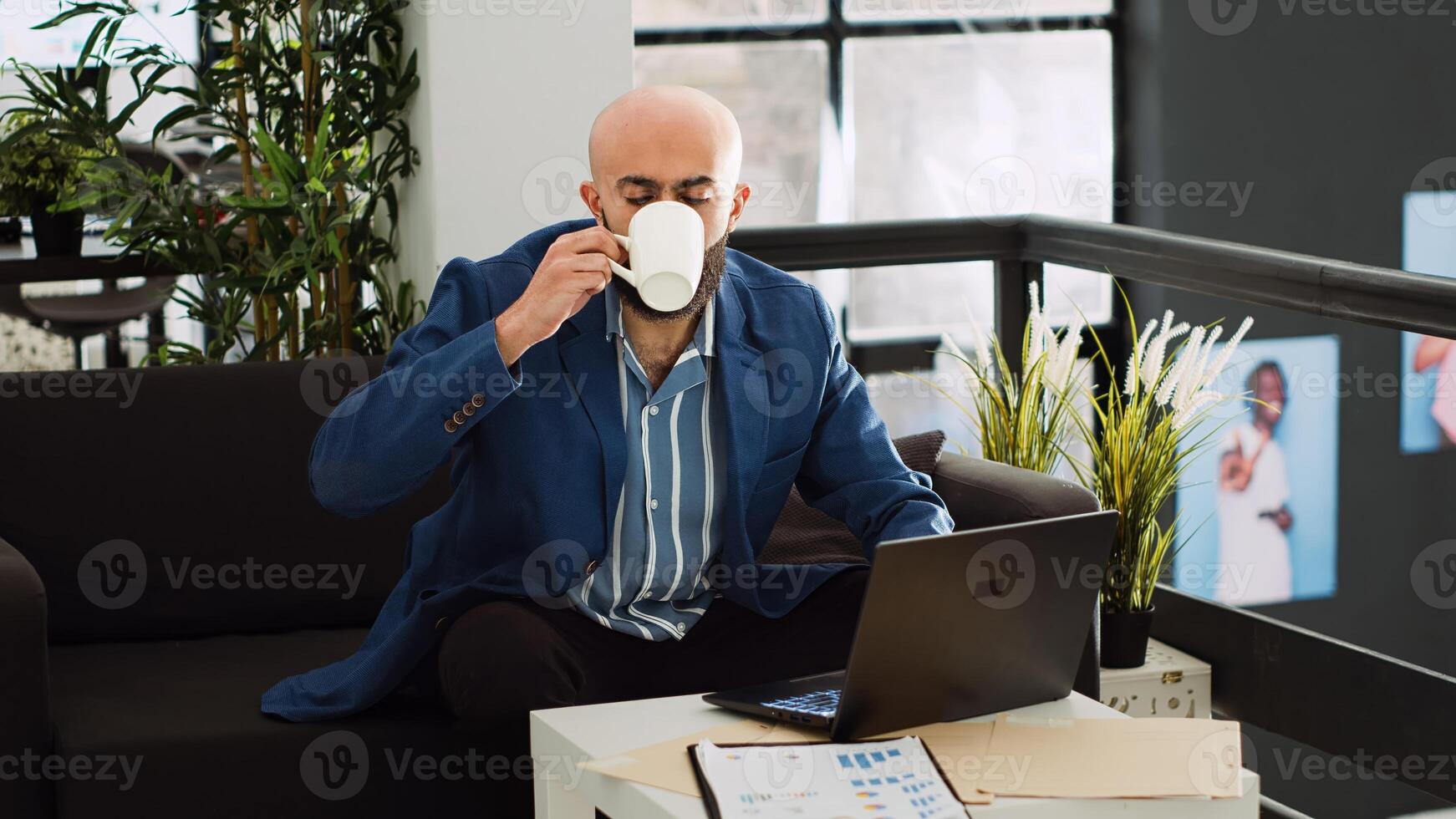 Company worker in startup office examining monthly statistics, trying to increase small business profit. Businessman looking at report on laptop to gather marketing information. photo