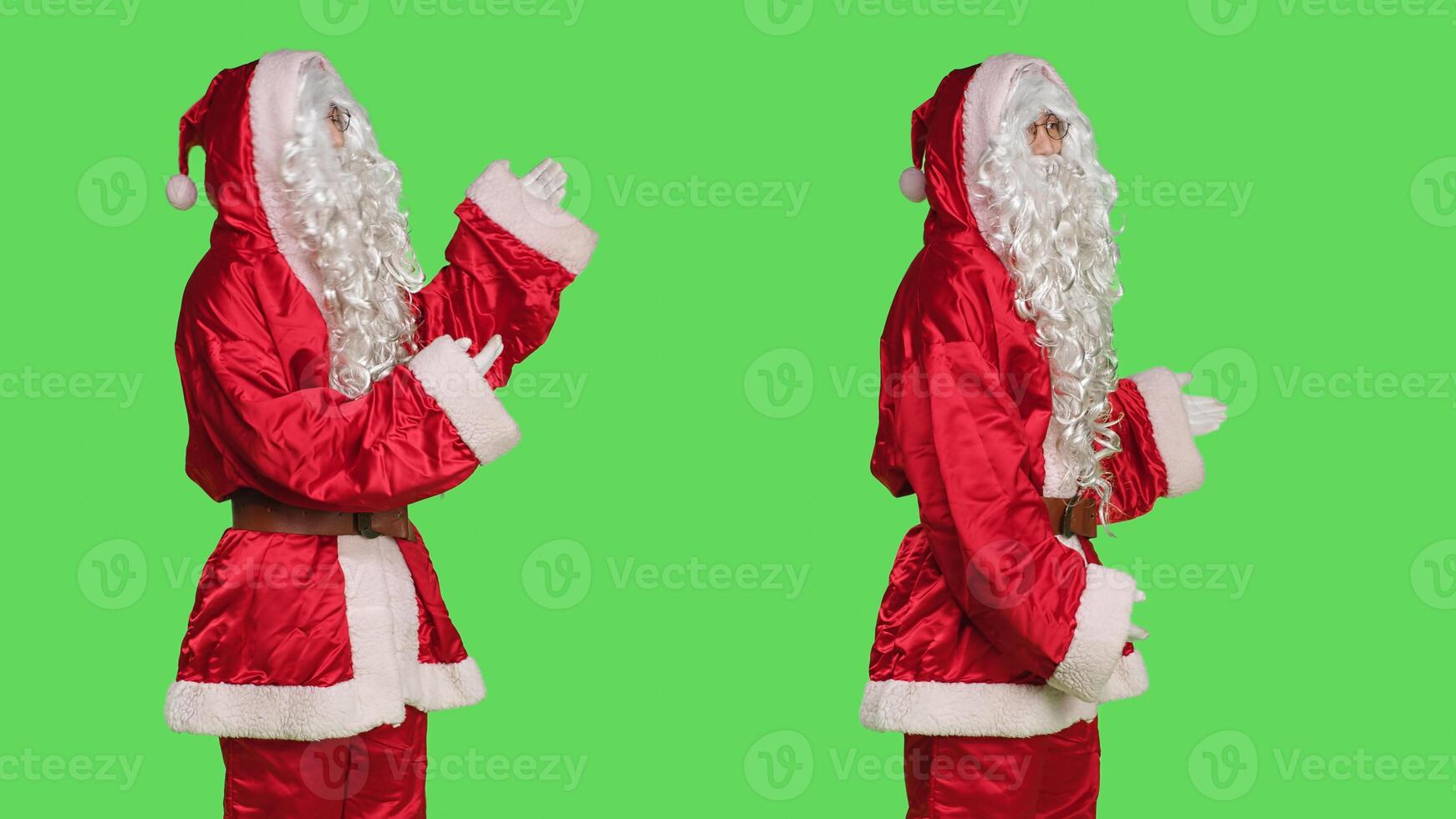 Father christmas advertising something, pointing aside while he stands against greenscreen backdrop with stanta claus festive costume. Man dressed like saint nick, xmas marketing campaign. photo