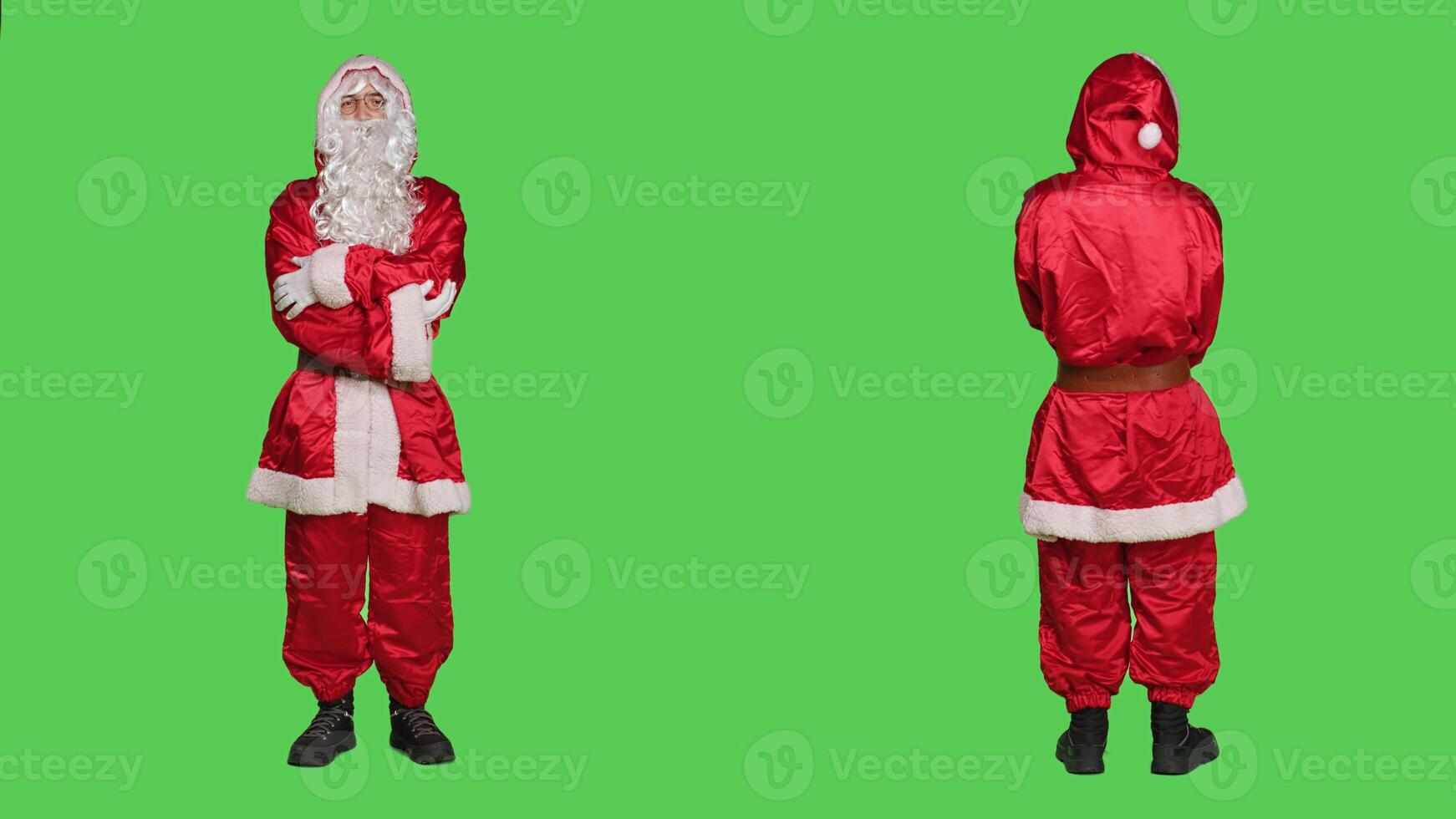 Saint nick laughing on camera, posing in red costume over full body greenscreen. Santa cosplay spreading christmas eve holiday spirit, portraying famous winter character with hat and glasses. photo