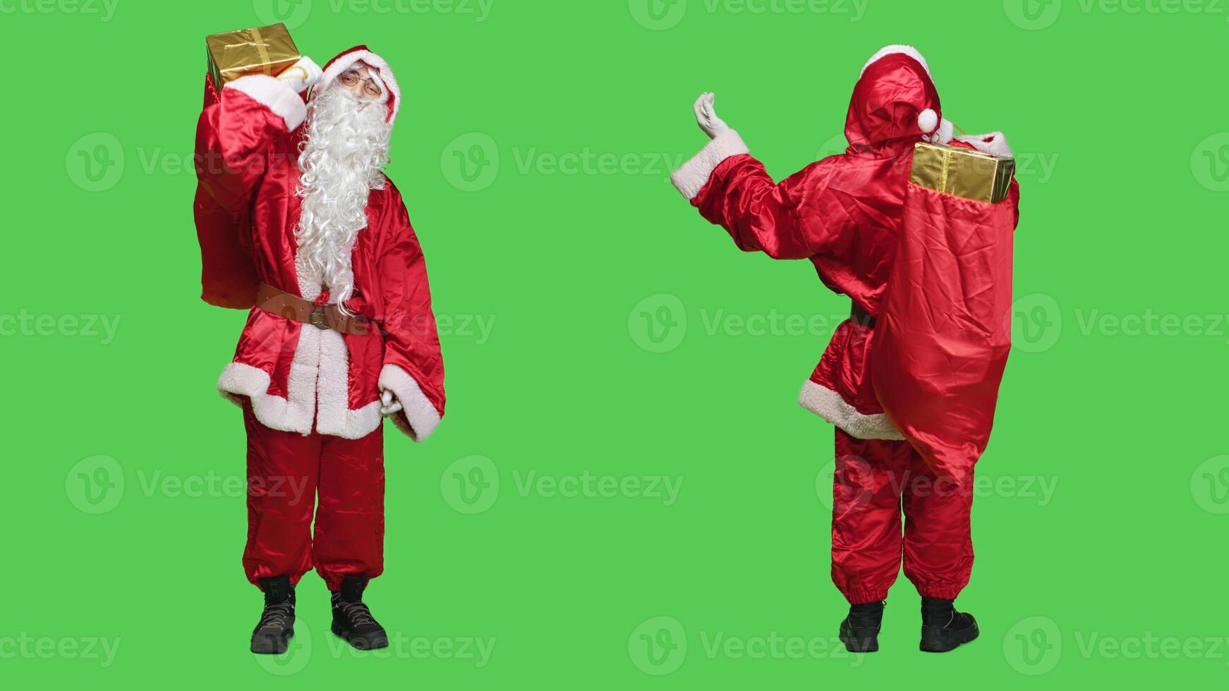 Santa claus with red bag says ho ho ho over full body greenscreen backdrop, wearing traditional holiday costume and glasses. Father christmas cosplay carrying sack with presents and toys. photo