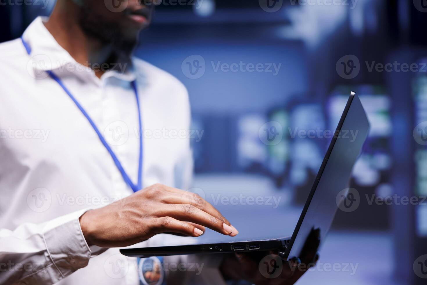 African american admin in data center housing numerous servers, storage devices and networking components providing vast amounts of computing power. Soecialist doing hardware maintenance photo