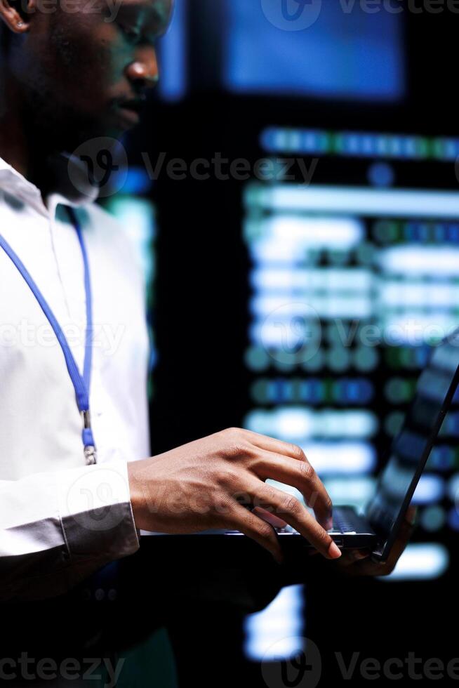 Admin checking event logs and diagnostic tools using laptop to identify server issues root cause. Technician looking over supercomputer operating system configuration settings photo