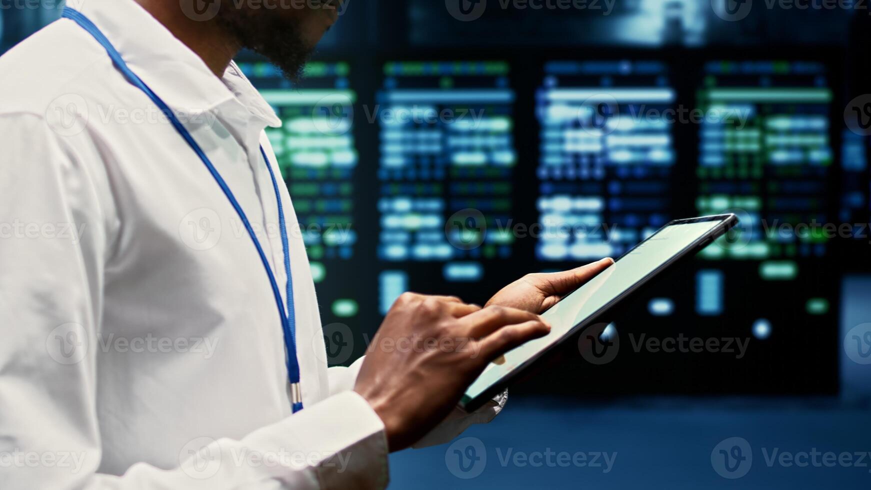 Skilled worker walking through supercomputers delivering web content to online customers. Repairman in server room using tablet to make sure critical systems are working errorless, close up photo