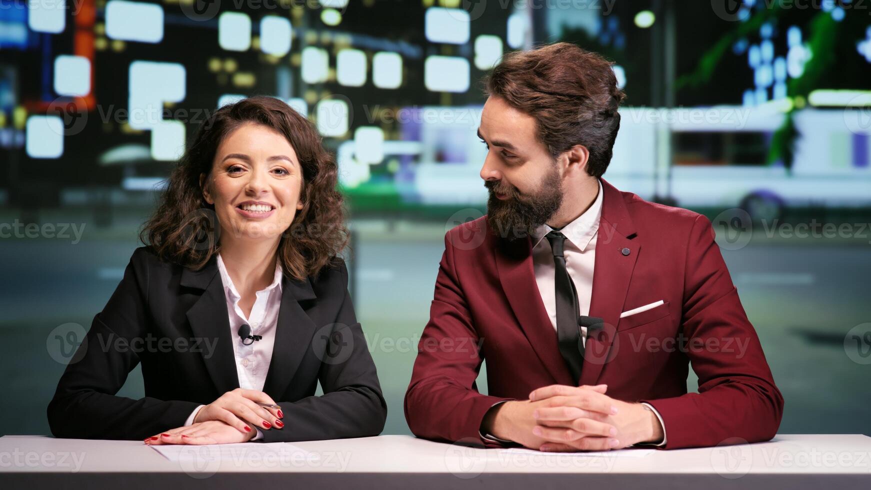 Media team hosting night talk show, discussing about international daily events in news studio. Two journalists addressing all breaking news topics live on television network. photo
