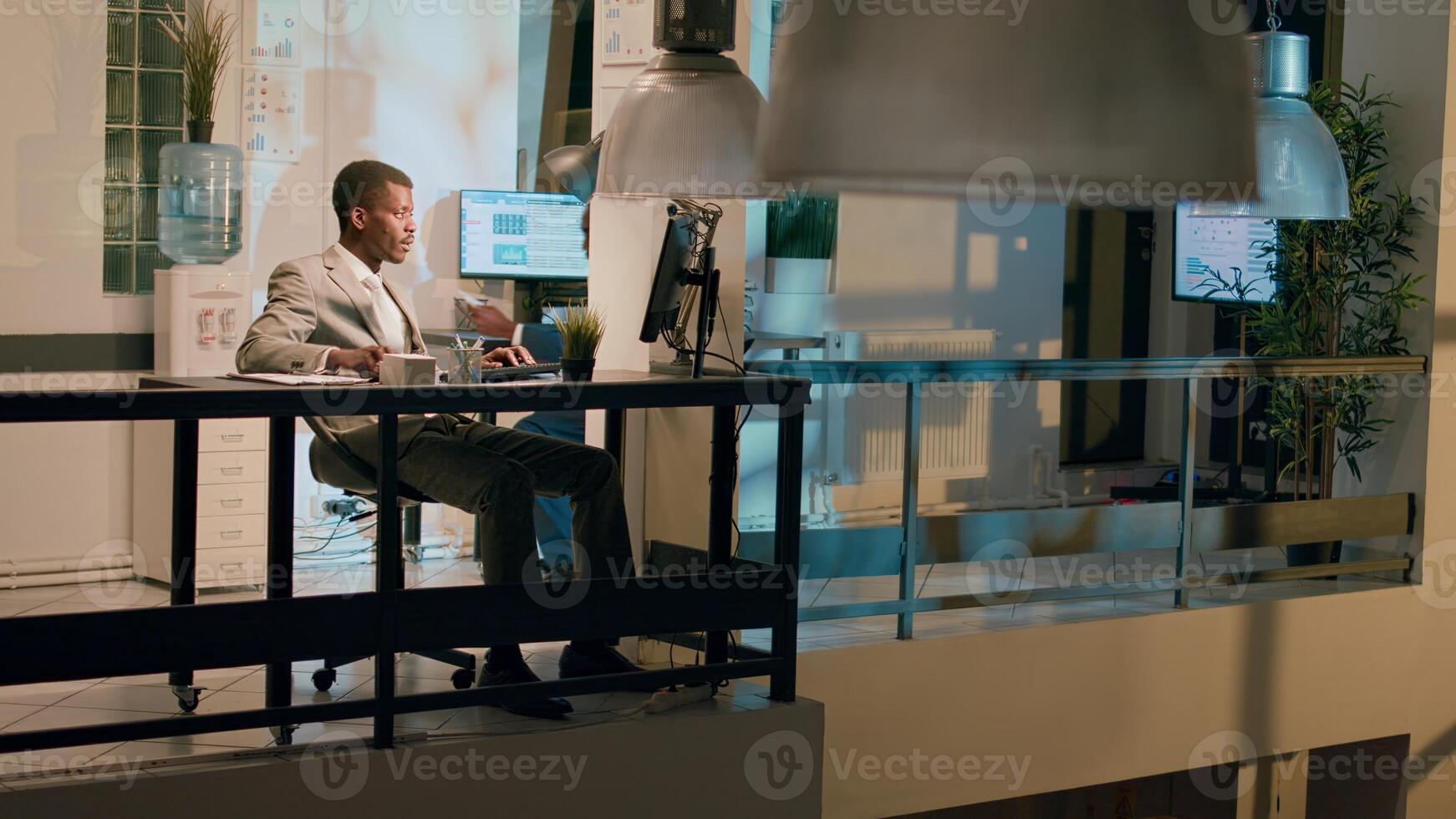 Management executive helping worker with auditing project task in office at night, laughing together. Business manager having fun with employee working with data charts during nightshift photo