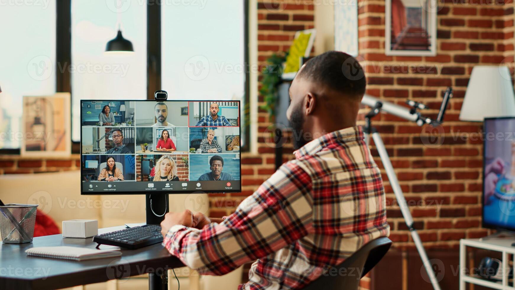 Joyful executive holding video conference meeting with remotely working international team. Employee teleworking in stylish welcoming apartment, discussing with colleguers during online video call photo