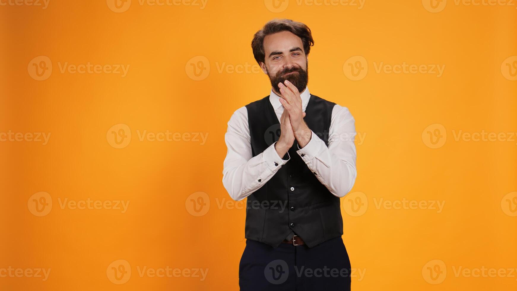Positive butler clapping hands on camera, applauding to express congratulations for achievement. Joyful restaurant worker with suit and tie cheering for someone in studio, showing admiration. photo