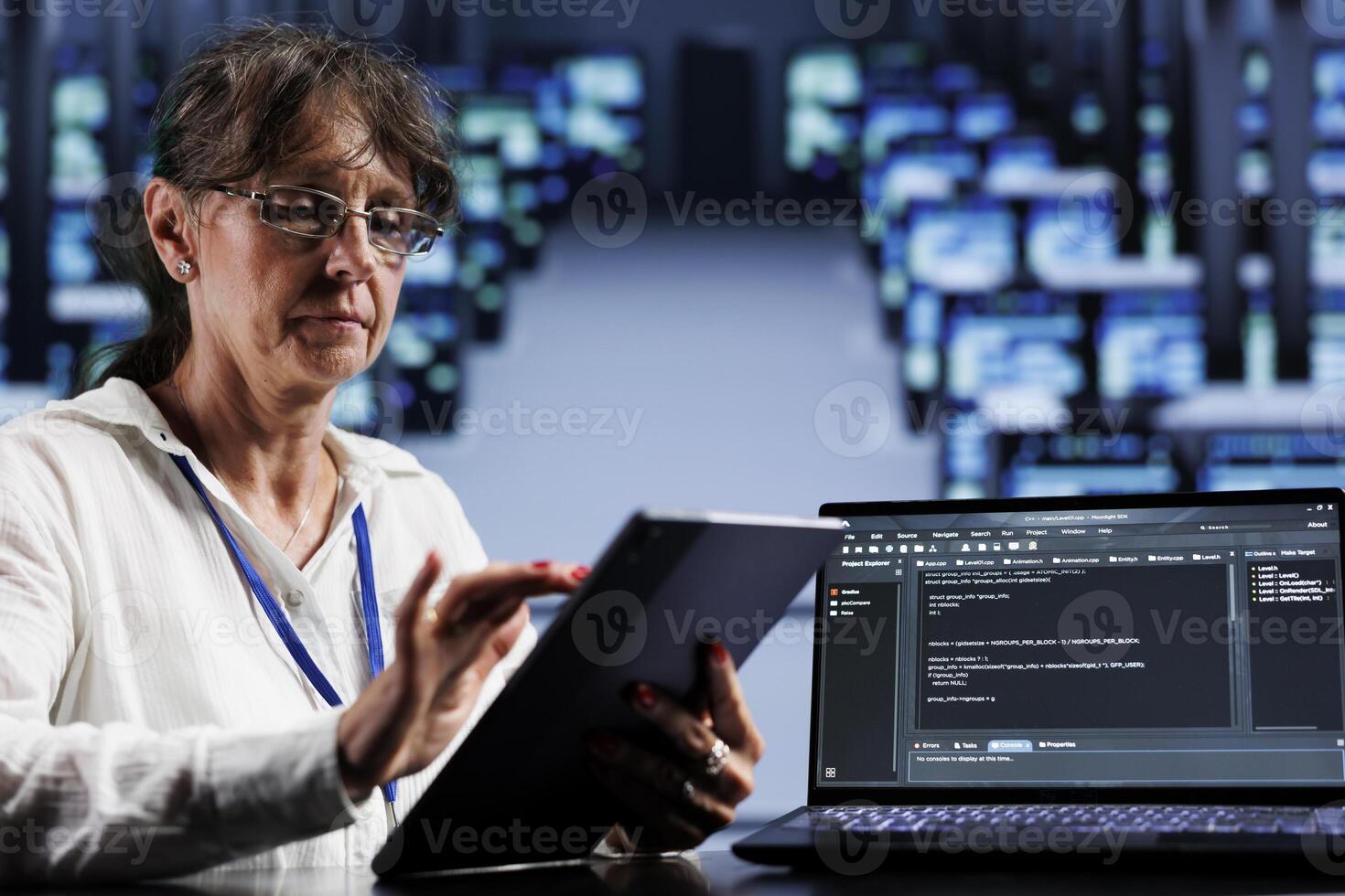 Senior developer writing script code in data center on laptop terminal. Experienced expert doing maintenance work in server hub, updating rigs software to prevent malfunctions photo