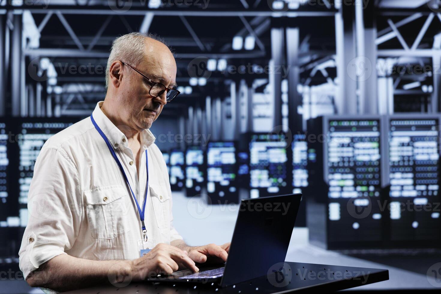 Experienced serviceman using laptop, setting up high bandwidth dedicated multiplayer gaming servers in high tech establishment to accommodate more traffic from worldwide locations and avoid low ping photo