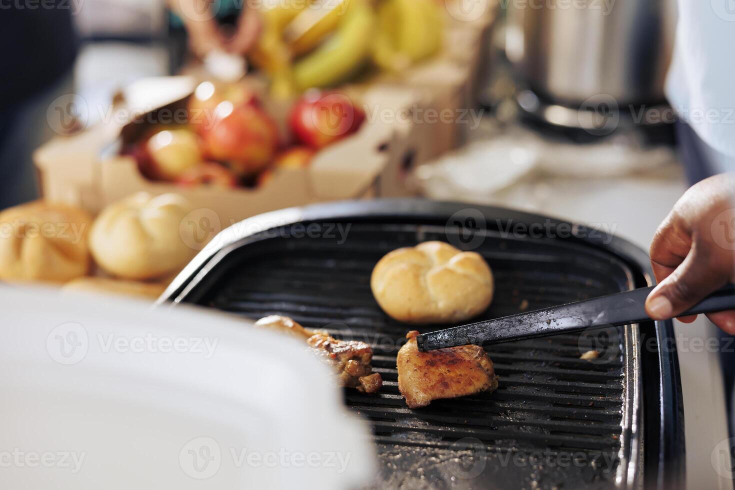 Close-up of african american individual preparing a healthy meal at a food drive. Charity worker providing nourishment for those in need showcasing the spirit of charity and volunteering. photo