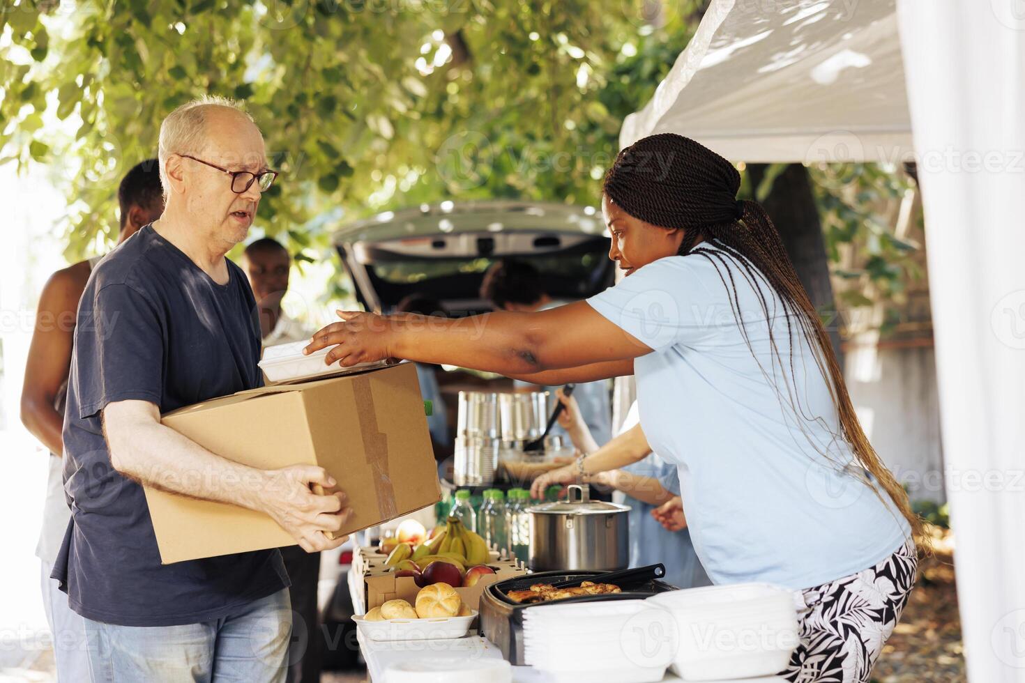 Group of volunteers distributing packaged food to those in need including homeless individuals and seniors. Their genuine act of charity brings happiness and relief to the less fortunate. photo