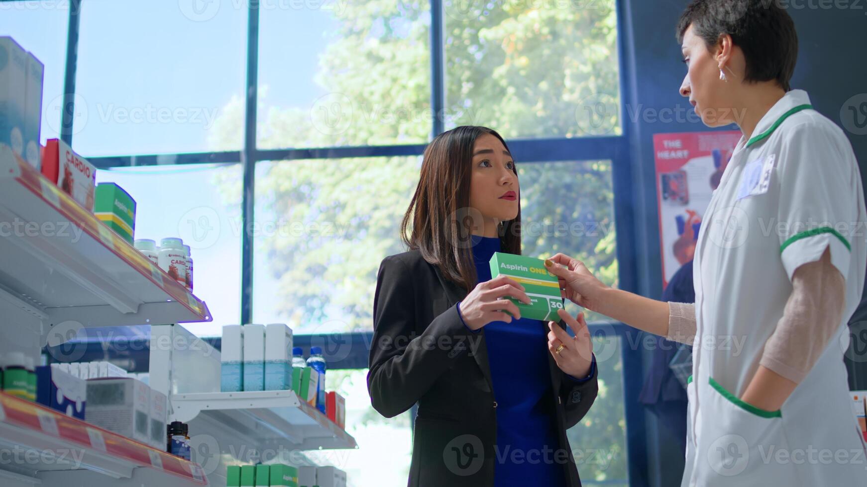 Asian client in modern apothecary asking experienced pharmacist for medical expertise. Licensed druggist helping customer trying to pick best pharmaceutical product to lower headache photo
