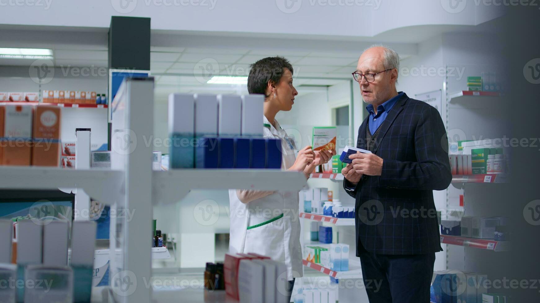 Older man feeling unwell visiting dispensary, looking to find pharmaceutical product to cure nauseating affliction, asking licensed healthcare employee for product suggestions photo