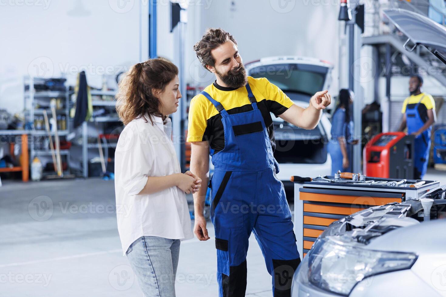 Technician in repair shop using augmented reality holograms to show customer car performance parameters. Trained garage employee using futuristic vr headset to examine damaged exhaust pipes photo