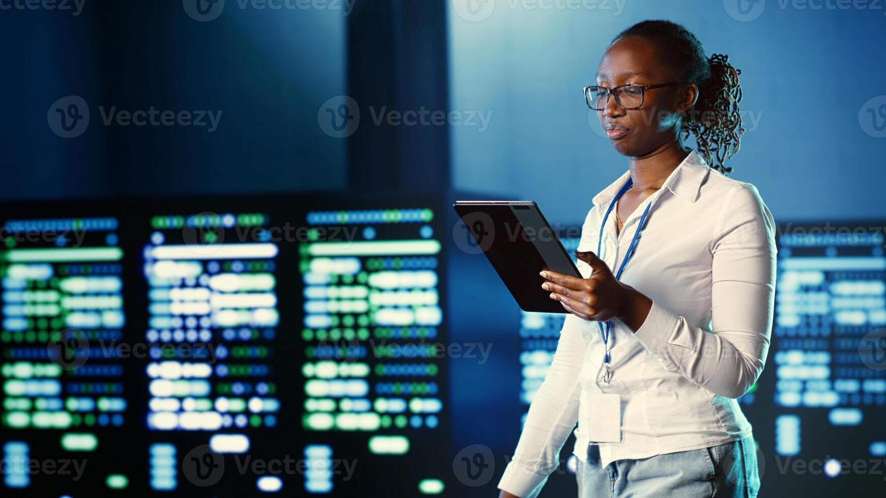 African american woman walking through data center systems providing processing resources for different workloads. Admin diagnosing server hub equipment tasked with solving complex operations photo