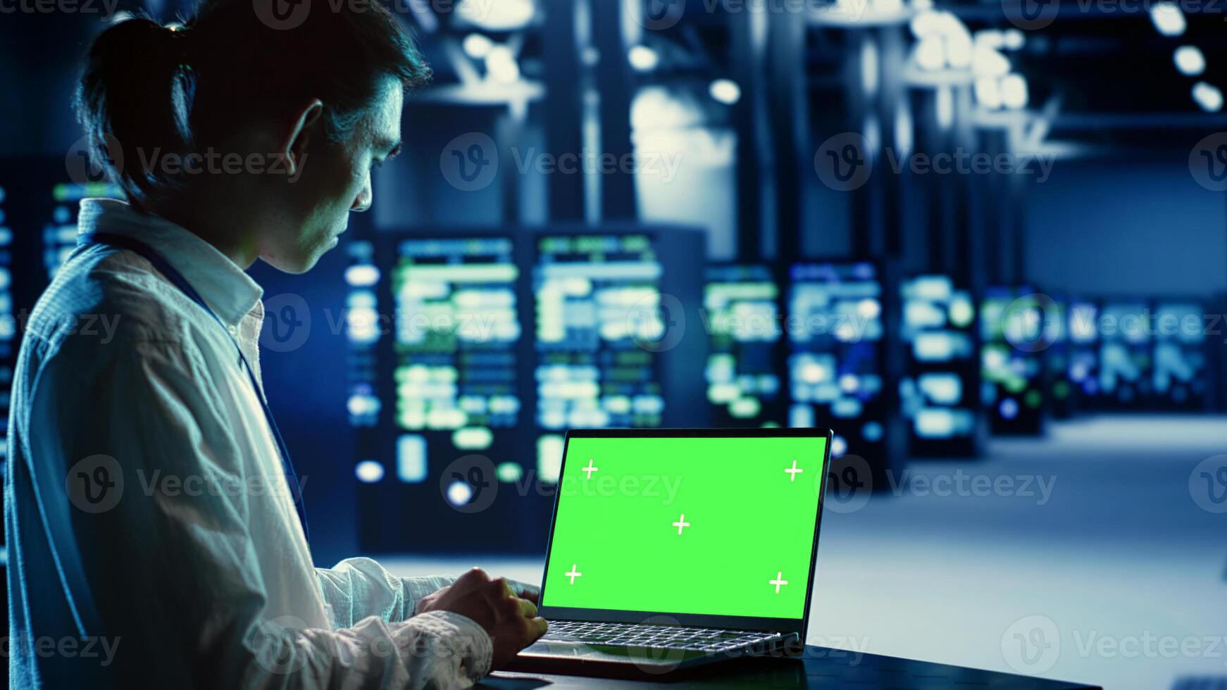 Employee using chroma key laptop to fix data center hardware clusters providing processing resources for different workloads. Engineer helped by green screen device to upgrade blade servers photo