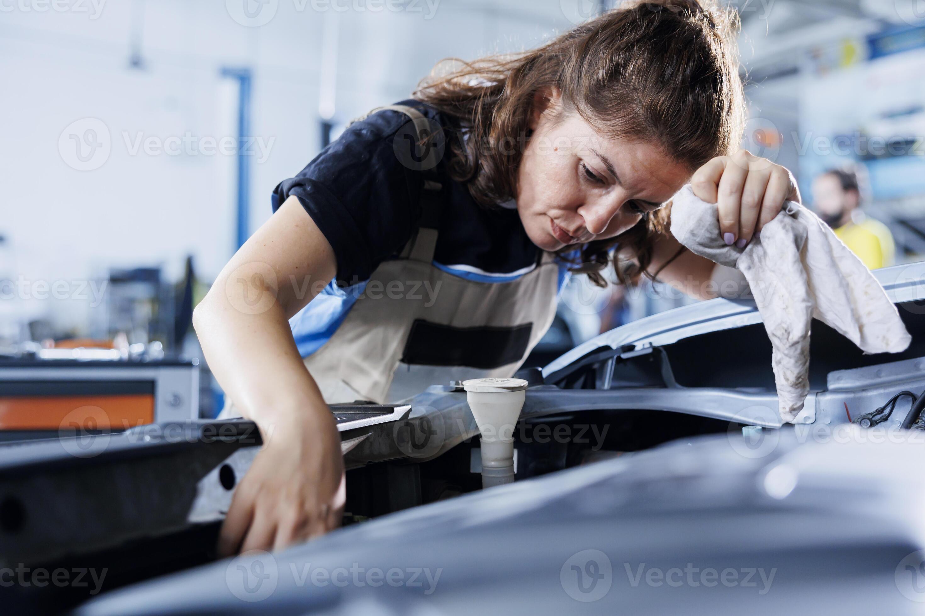 Certified professional in garage finishing fixing car, looking