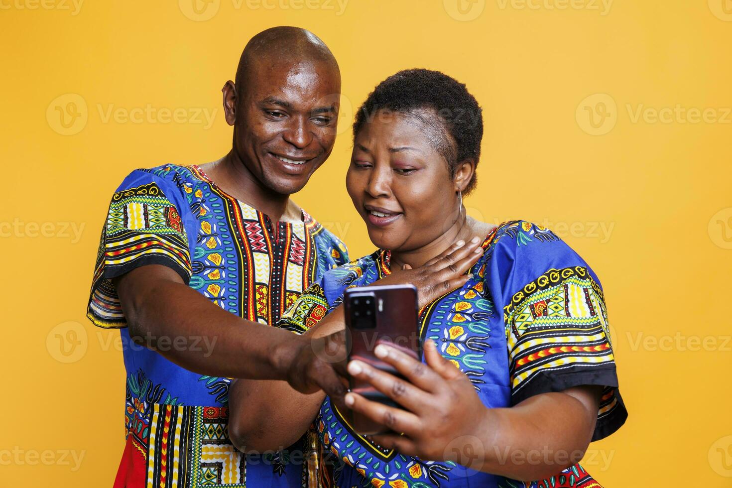 Smiling wife and husband family couple enjoying smartphone app together. Man and woman pair with cheerful expression using social media application software on mobile phone photo